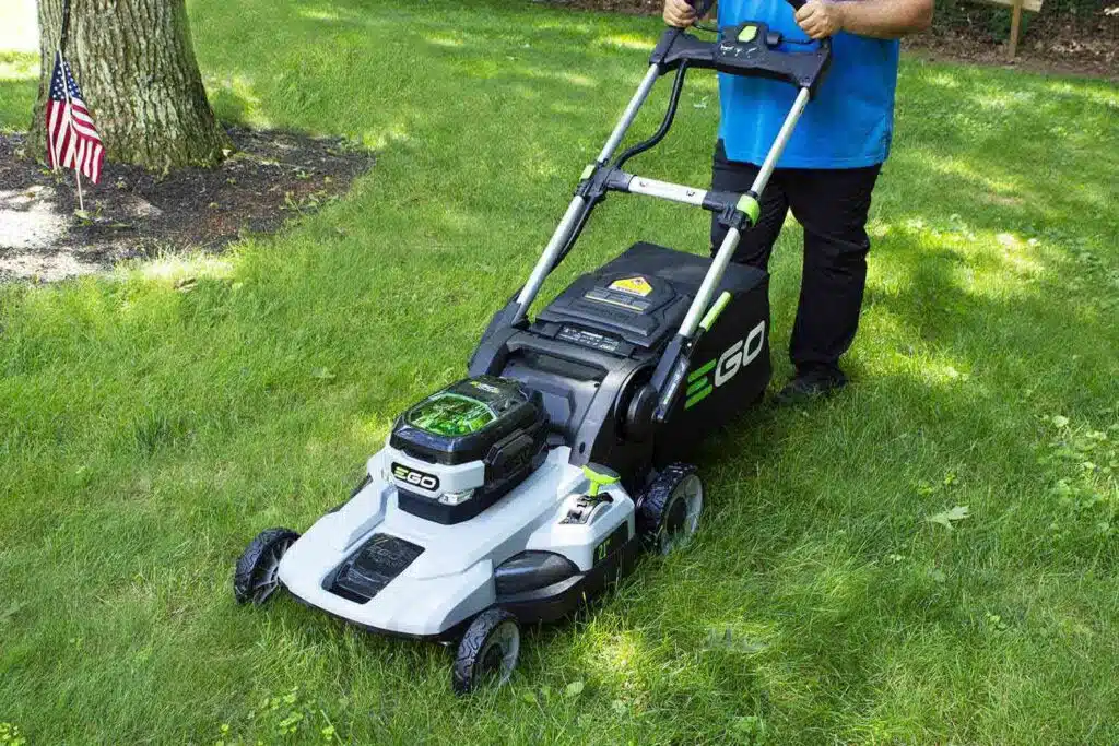 Man mowing lawn with battery-powered mower