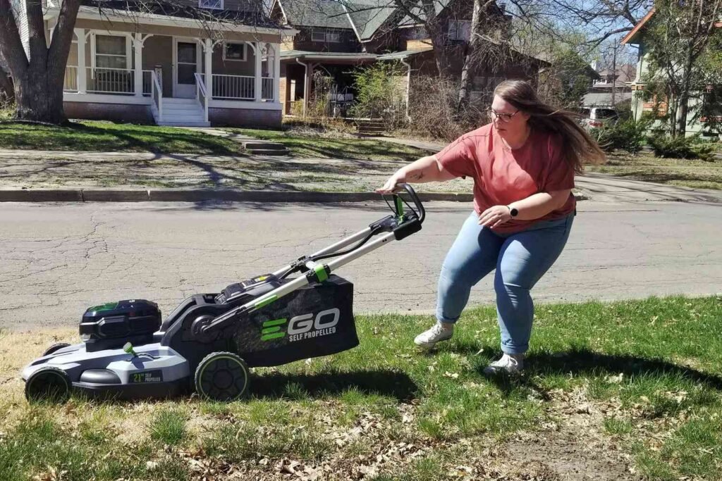 Woman pushing a self-propelled mower on grass
